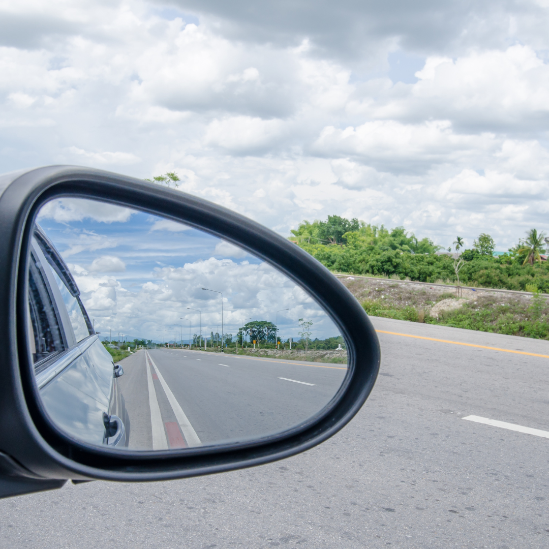 the rear view mirror of a car on the road