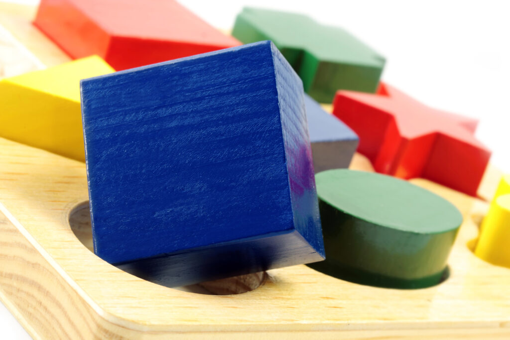 Photo of wooden blocks trying to put square block in round hole