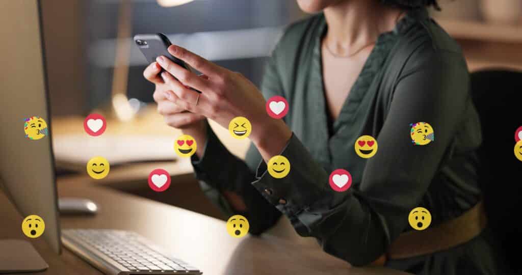 woman sitting at desk holding phone with emojis overlaying the pictures